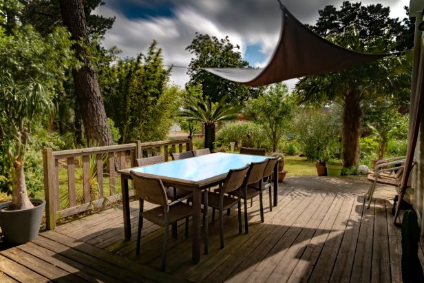 Hyggelig terrasse med solsejl og havemøbler